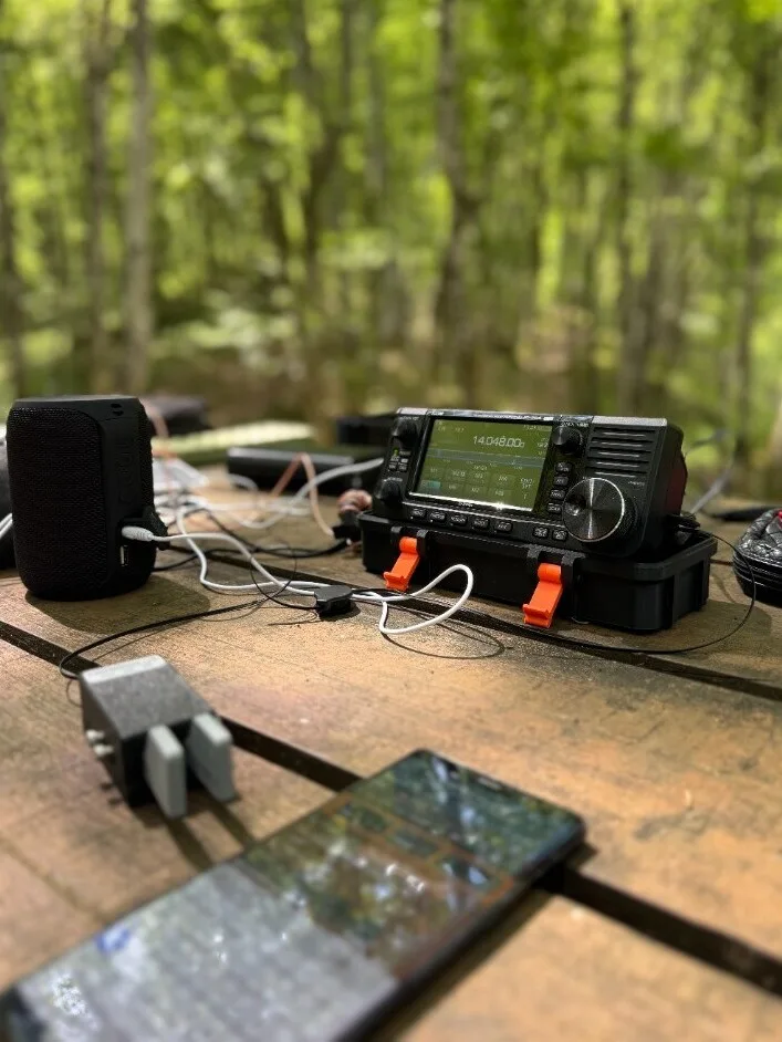 Portable Icom station on a picnic table in the forest during a park activation