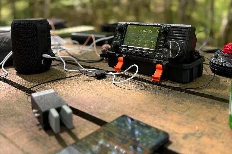 Portable Icom station on a picnic table in the forest during a park activation