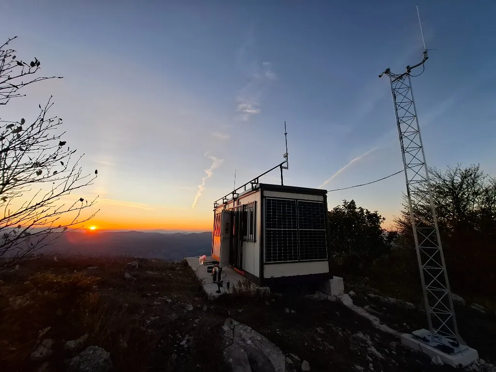 Radio-lokalitet Čemernica u zalasku sunca sa solarnim panelima i antenskim stubom